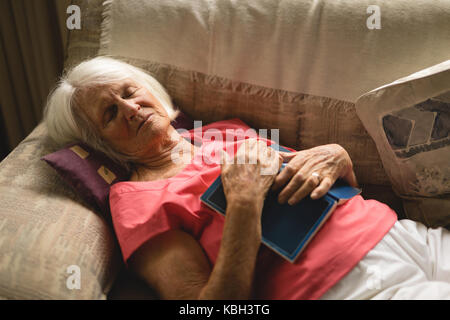 Ältere Frau schläft auf dem Sofa im Wohnzimmer zu Hause Stockfoto