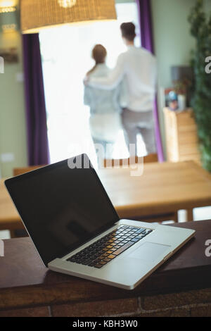 Blick auf Laptop auf hölzernen Tisch während der paar in Hintergrund Stockfoto