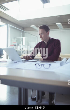 Architekt mit Laptop am Tisch im Studio Stockfoto