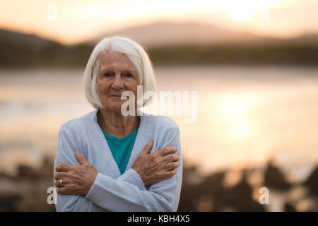 Portrait der älteren Frau, die am Strand Stockfoto