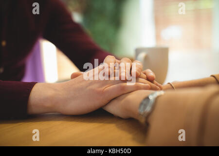 In der Nähe von Paar Hände halten beim Entspannen zu Hause. Stockfoto