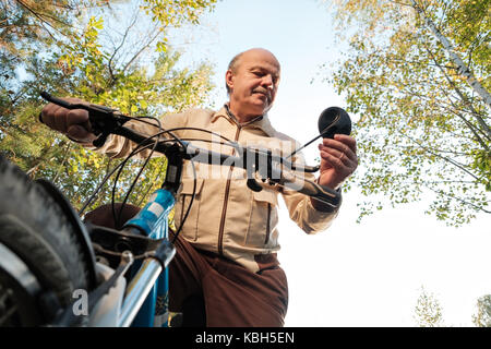 Älterer Mann auf Radtour in der Landschaft
