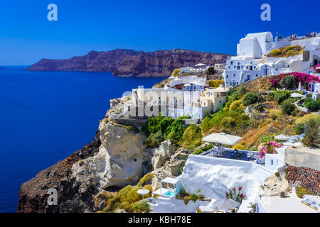 Stadt Oia, Santorini, Griechenland. Traditionelle und berühmte weisse Häuser und Kirchen mit blauen Kuppeln auf die Caldera, Ägäis. Stockfoto