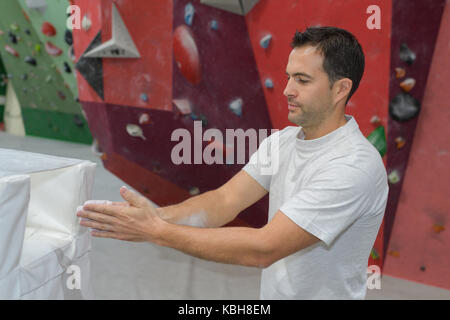 Die Anwendung Chalk Powder auf die Hände Stockfoto