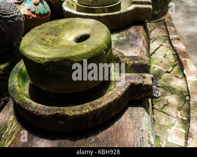Alte Mühlstein haben grüne Flechten um und Alten Mühlstein auf alte hölzerne Bretter Stockfoto