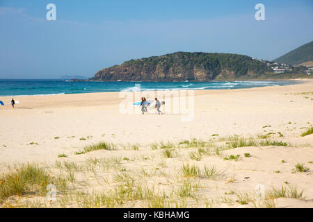 Surfer auf dem Sand über Boomerang Beach in Pacific Palms, New South Wales, Australien Stockfoto