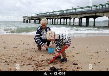 Großmutter Rosemary und zwei-jährige Finley spielen auf Boscombe Strand, Bournemouth, Großbritannien ist auf Kurs für starke Regenfälle und Stürme als Reste des Hurrikans Lee hinzufügen "extra Oomph" zu einem Tiefdruckgebiet, das über den Atlantik, Meteorologen sagten. Stockfoto