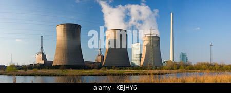 Panorama-aufnahme von einem Kohlekraftwerk mit drei Kühltürme in warmes Sonnenlicht gefeuert. Stockfoto