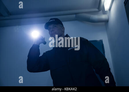 Reifen Sicherheit Schutz suchen mit Taschenlampe im Bürogebäude Stockfoto