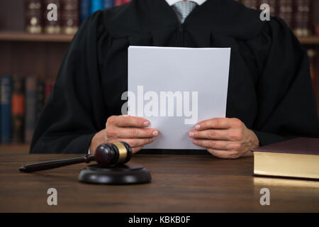 Mittelteil des Richters lesen Dokument am Schreibtisch im Gerichtssaal Stockfoto