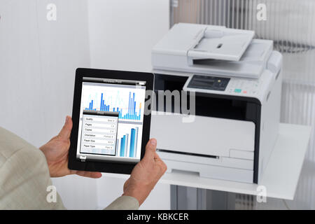 Zugeschnittenes Bild des Befehls Geschäftsmann, drucken Sie auf digital Tablet im Büro Stockfoto