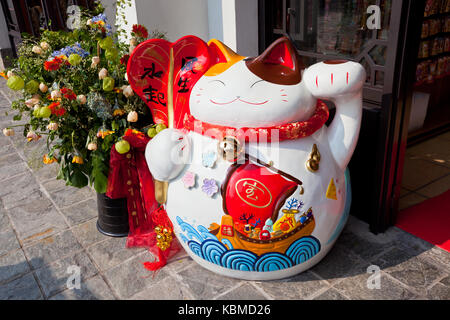 Chinesische lucky cat Figurine auf einer Straße Stockfoto