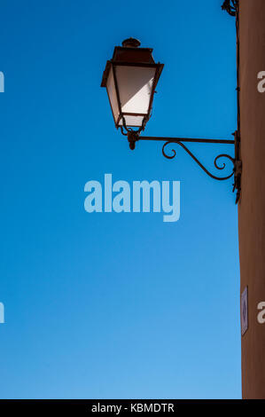 Urbanes Mobiliar und Stadt Architektur: Eine schmiedeeiserne Lampe und einem blauen Himmel im Hintergrund Stockfoto