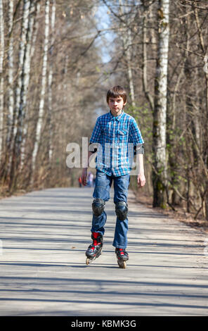 Kid Schlittschuhlaufen auf Inline-skates in Spring Park Stockfoto