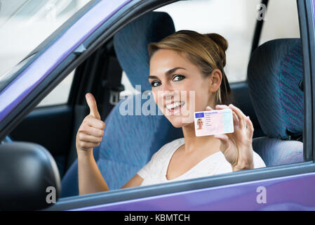 Portrait von neugierige junge Frau, Lizenz, während im Auto sitzen Stockfoto