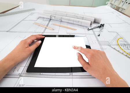 Verfasser der Hände mit leeren Digital Tablet über Blueprint im Büro. Blueprints wurden von Fotograf erstellt Stockfoto