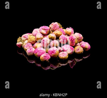 Getrocknete pfingstrose Blütenknospen. Chinesischer Tee Additive, die für das Aufbrühen. Auf einem schwarz glänzenden Hintergrund mit echten Reflexion. Blumen Tee Stockfoto