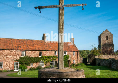 Sonnigen Tag in Stenton Village Green, East Lothian, Schottland, Großbritannien mit roten Schutt Steinhütten, dovecot und den alten Markt Waage Stockfoto