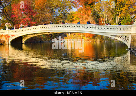 NEW YORK, USA - 16. NOVEMBER 2016: Menschen zu Fuß auf einer Brücke im Central Park an einem sonnigen Herbsttag mit Stockfoto