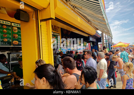 Linie der Besucher und Touristen an den berühmten Nathan Restaurant an der Strandpromenade von Coney Island. Stockfoto