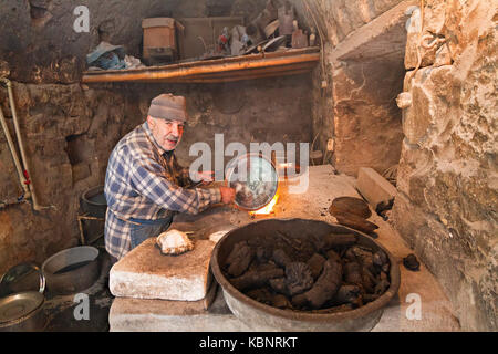 Mann, der Kupfer mit Zinn bedeckt in Mardin, Türkei Stockfoto