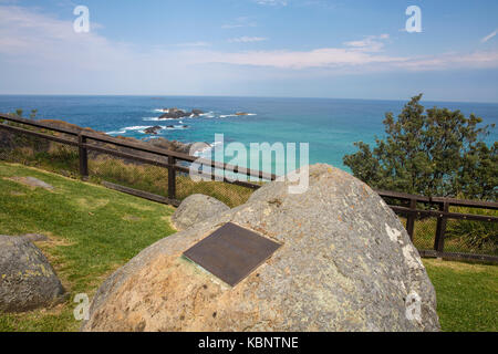 Plakette zum ersten Lichtwart am Sugarloaf Point Leuchtturm mit Robbenfelsen in der Ferne, Seal Rocks, NSW, Australien Stockfoto