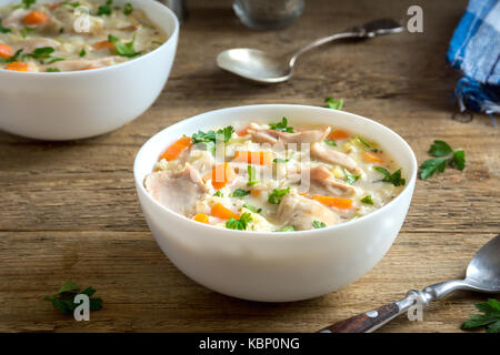 Huhn und wilder Reis Suppe. hausgemachte Frische cremige Suppe mit Hähnchen, Gemüse und Wildreis in weiße Schüssel. Stockfoto
