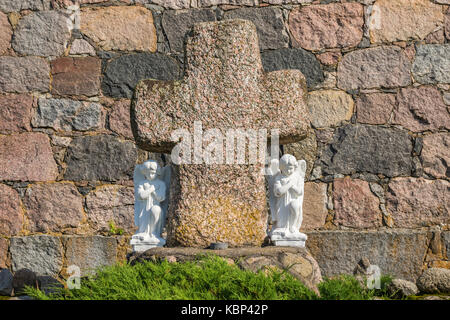 Engel in der Nähe des Steinernen Kreuz auf dem Hintergrund einer mächtigen Wand Stockfoto