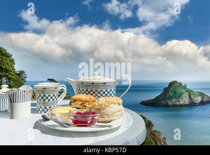 Devon Cream Tea mit Scones und Erdbeermarmelade mit Blick auf Blick von Thatcher Rock in Torquay, Devon, an einem heißen und sonnigen Sommer. Meeresfrüchte Küste Stockfoto