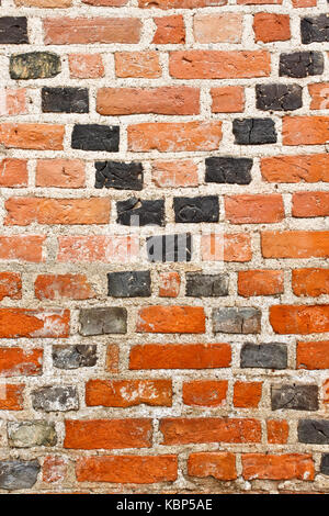 Alten grunge Red brick wall mit schwarzen Kreuzung diagonale Linien Stockfoto