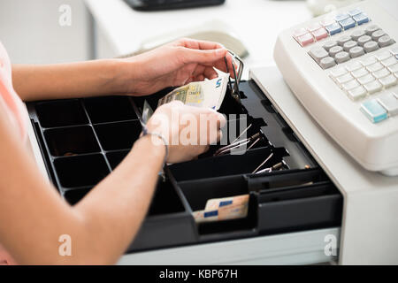 Hohe Betrachtungswinkel der weiblichen Kasse Suche nach Änderung der Kasse Schublade im Supermarkt Stockfoto