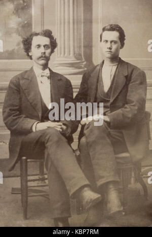 Amerikanische Archiv monochrome Studio Portrait auf Platte Tintype zwei junge Männer sitzen auf Stühlen, eine mit einem Schnurrbart, im späten 19. Jahrhundert genommen, New York, USA Stockfoto