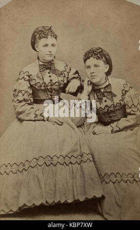 Amerikanisches Archiv monochrome Studioporträt-Fotografie von zwei jungen Frauen in passenden gestickten Kleidern, benannt als Schwestern Elsie und Matilda Gage, aufgenommen im späten 19. Jahrhundert von E Murphy und Brothers, Binghamton, NY, USA Stockfoto