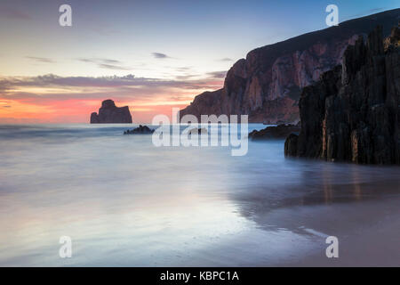 Sonnenuntergang am Strand von Masua, vor dem Pan di Zucchero Reef. - Masua, Sulcis Iglesiente, Iglesias, Sardinien, Italien. Stockfoto