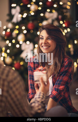 Glückliche Frau empfangen Weihnachtsgeschenk von ihrem Mann Stockfoto