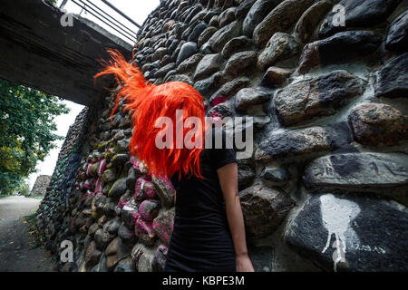 Rote Haare flattern. Dunkle Mauer aus Stein. Creepy horror Bild Stockfoto