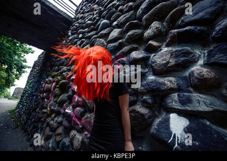 Rote Haare flattern. Dunkle Mauer aus Stein. Creepy horror Bild Stockfoto