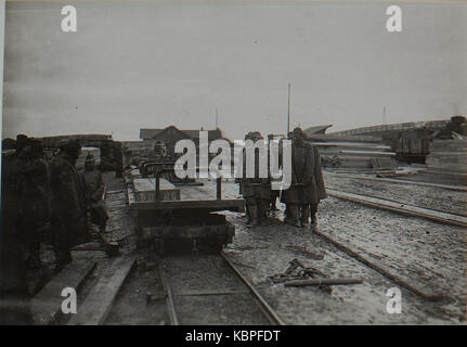 Eine Zeichnung aus einem historischen Buch, das den Transport von Stahlbetonträgern (Feldbahn) darstellt und seine Rolle im Bau des frühen 20. Jahrhunderts während des Ersten Weltkriegs zeigt. Stockfoto