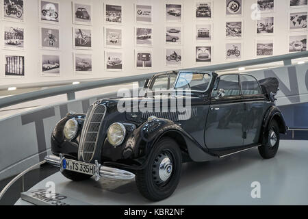 Ein schwarzes Oldtimer vor ein Bild an der Wand im BMW Museum, München, ein berühmter Deutschland auto Marke Stockfoto