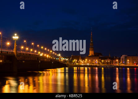 St. Peter's Kirche und der Brücke über den Fluss Daugava in Riga bei Nacht Stockfoto