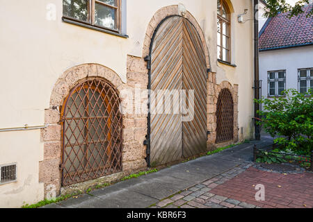 Hölzerne Tür und Fenster mit metall gitter in einem alten Haus, Altstadt von Riga. Stockfoto
