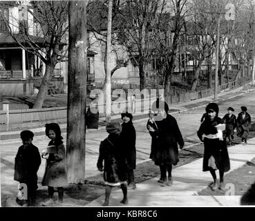 Eine Gruppe von Kindern im Winter Mäntel zu Fuß zur oder von der Schule Stockfoto