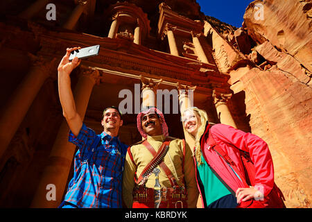 Touristen nehmen einen Schuß mit einem Beduinen Polizist an khazne firaun Al, Al khazneh treasury Building, Petra, Wadi Musa, Jordanien Stockfoto