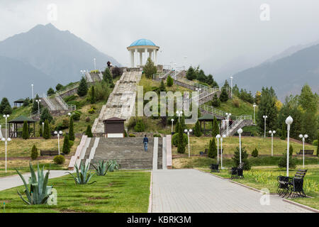 Almaty, Kasachstan, 23. September 2017: Blick auf das Denkmal mit Treppen und Berge bei Sonnenaufgang Himmel Hintergrund in dendra Park der erste Präsident nu Stockfoto