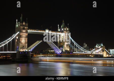 Tower Bridge mit der Straße aufgehoben die Passage des 'Dixie Queen' Raddampfer passieren. Bei Nacht fotografiert zu ermöglichen. Stockfoto