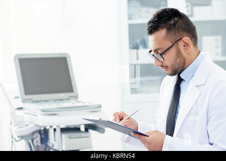 Bärtige Arzt Eingehüllt in Arbeit Stockfoto