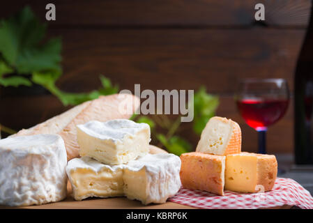 Variation von Käse, Wein und Brot auf einem Tisch aus Stein Stockfoto