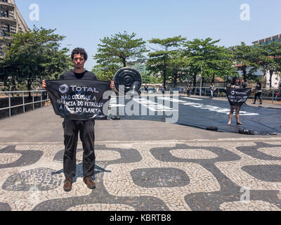 Rio de Janeiro, Brasilien. September 2017. Die Menschen protestieren gegen Öl- und Gasbohrungen im Amazonas. Greenpeace-Aktivisten in schwarz gekleidet mit Öl Stockfoto