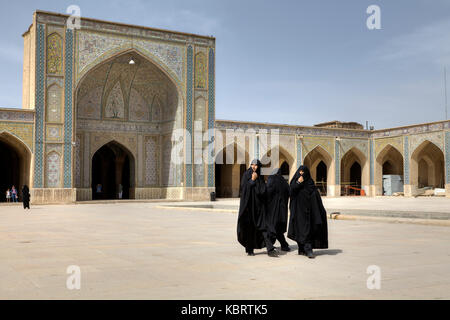 Provinz Fars, Shiraz, Iran - 19. April 2017: Muslimische Frauen in schwarzen Tschador im Innenhof der Moschee Vakil. Stockfoto