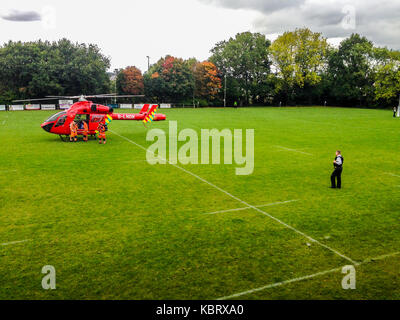 Woodford Green, London, UK. 30. September 2017. London's Air Ambulance helicopter G-LNDN landet an der Woodford Rugby Fußball Club Highams Boden in Woodford Green in Reaktion auf einen Bericht von einem Zuschauer, einen Herzinfarkt zu erleiden. Den Woodford v Chelmsford Match war für 40 Minuten unterbrochen, während die Sanitäter zu dem Unfall, der in der Lage war, auf der Straße zu verlassen. Woodford ging auf das Match zu gewinnen. Die Air Ambulance ist in London Freimaurer unterstützt. Credit: Mark Dunn/Alamy leben Nachrichten Stockfoto